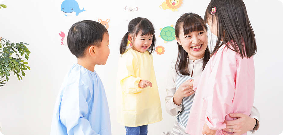 幼稚園・保育園・こども園で笑顔で楽しく遊ぶ児童と先生